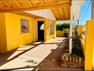 a yellow house with a door and a porch at El tabo house in El Tabo
