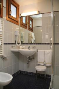 a bathroom with two sinks and a glass shower at Hotel Giudecca Venezia in Venice