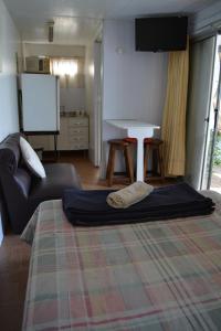 un salon avec un grand lit et un écran dans l'établissement Orejano, à Mercedes