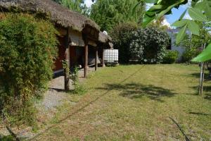 a house with a grass roof and a yard at Orejano in Mercedes