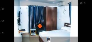 a small bedroom with a bed and a curtain at MoExoticRoyaleServices in Ikorodu