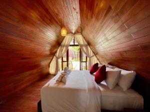 une chambre avec un lit dans une pièce en bois dans l'établissement Dalung Tropical, à Dalung