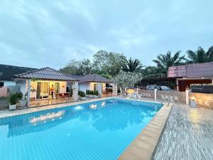 a swimming pool in front of a house at All Times Pool Villas in Ban Ta Khun