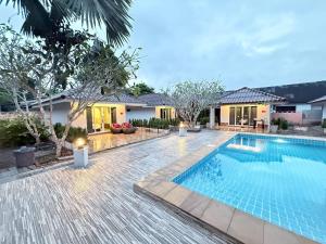 a swimming pool in front of a house at All Times Pool Villas in Ban Tha Khun
