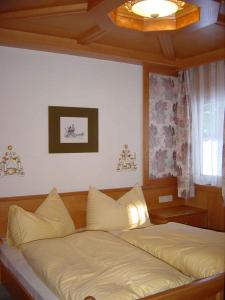 ein Bett in einem Schlafzimmer mit einer Decke in der Unterkunft Ramsauer Sonnenalm in Ramsau am Dachstein