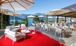 
a patio area with tables, chairs and umbrellas at Seerausch Swiss Quality Hotel in Beckenried
