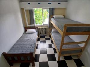 - 2 lits superposés dans une chambre avec un sol en damier dans l'établissement Casa central hostel, à San Carlos de Bariloche