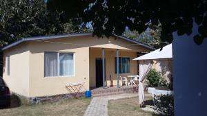 a small white house with a porch and a table at Bungalows St. Nicola in Ahtopol