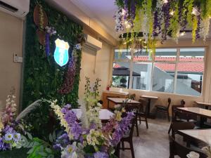 un restaurant avec des tables et des fleurs sur le mur dans l'établissement Pahang Rest House Raub, à Raub