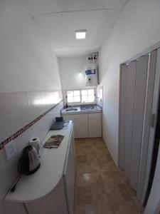 a small white kitchen with a counter and a stove at Departamento LA PALMERA ARGENTINA in San Luis