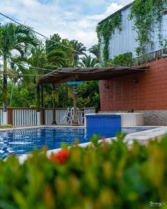a swimming pool with an umbrella and a building at Yorhanys Hotel in Puerto Barrios