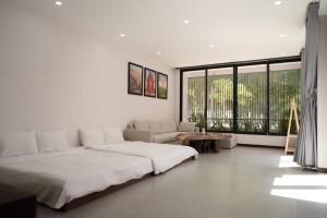 a white room with a bed and a couch at Ranglux Homestay Phan Rang in Phan Rang–Tháp Chàm +38 photos