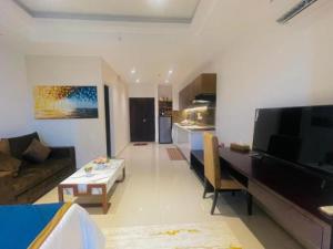 a living room with a couch and a table and a kitchen at Studio apartment ocean breeze in Negombo
