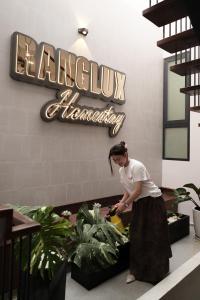 a woman standing next to plants in a lobby at Ranglux Homestay Phan Rang in Phan Rang–Tháp Chàm
