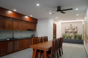 a kitchen with a wooden table and wooden cabinets at Ranglux Homestay Phan Rang in Phan Rang–Tháp Chàm