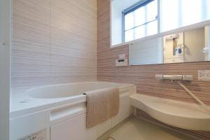 a bathroom with a tub and a sink and a mirror at Blue moon house miyama in Funabashi +16 photos