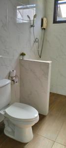a white bathroom with a toilet and a shower at River Bend Villas in Mae Rim