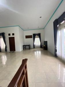a large room with a tile floor and blue walls at Homestay loteng in Madasari