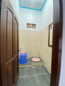 a bathroom with a pink toilet in a room at Homestay loteng in Madasari