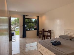 a bedroom with a bed and a table and a window at Sea La Vie Guesthouse in Pooc