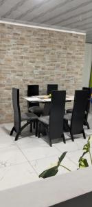 einen Tisch und Stühle in einem Zimmer mit Ziegelwand in der Unterkunft Casa Doña Blanca in Guaduas