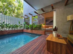 una piscina su una terrazza in legno con tavolo di Villa Dinova a Mantaak