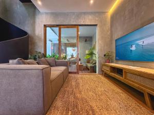 un soggiorno con divano e TV a grande schermo di Villa Dinova a Mantaak