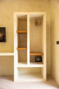 een boekenplank met een klok in een kamer bij Terracota Villas in Kuta Lombok