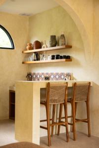 een keuken met een tafel met stoelen en planken bij Terracota Villas in Kuta Lombok