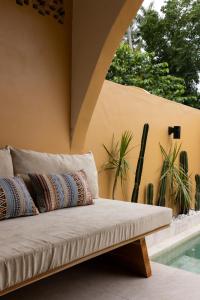 een bed met kussens naast een zwembad bij Terracota Villas in Kuta Lombok