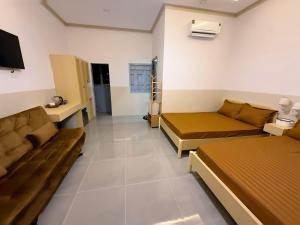 a room with two beds and a couch in it at Homestay Ly Angela in Ấp Mỹ Hải