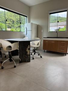 an office with a table and two chairs and a refrigerator at Tiny House Campeche - Vista do Lampião in Florianópolis