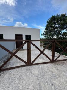 a wooden gate in front of a white building at Tiny House Campeche - Vista do Lampião in Florianópolis