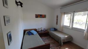 a room with two beds and a window at Chalet de campo in Piriápolis +22 photos