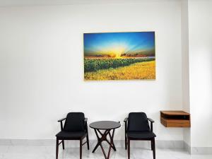a table and chairs in a room with a painting on the wall at LTC Hotel in Long Thành