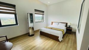 a bedroom with a bed and a mirror in it at LTC Hotel in Long Thành