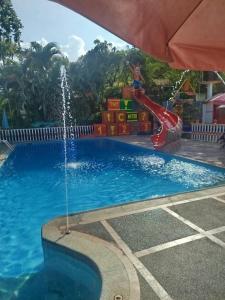 una piscina con scivolo d'acqua in un parco giochi di Villa Itzae Hotel - Piscina y Naturaleza a Viotá