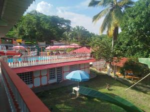 un edificio con un ombrello blu davanti di Villa Itzae Hotel - Piscina y Naturaleza a Viotá