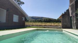 a pool of water in front of a building at Chalet de campo in Piriápolis