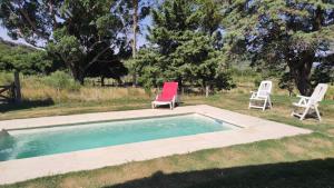 two chairs sitting next to a swimming pool at Chalet de campo in Piriápolis