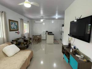 a living room with a couch and a flat screen tv at Chácara Quinta do Sol in Antonina
