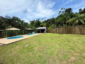 a large yard with a fence and a backyard with anophe at Chácara Quinta do Sol in Antonina