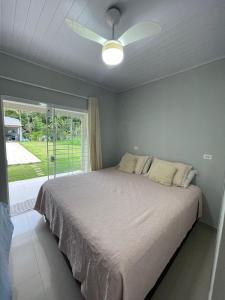 a bedroom with a bed with a ceiling fan at Chácara Quinta do Sol in Antonina +20 photos