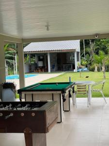 a patio with a pool table and a house at Chácara Quinta do Sol in Antonina