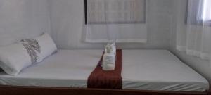 ein kleines Bett mit einer Flasche darauf in der Unterkunft Abejo Homestay in El Nido + 12 Fotos