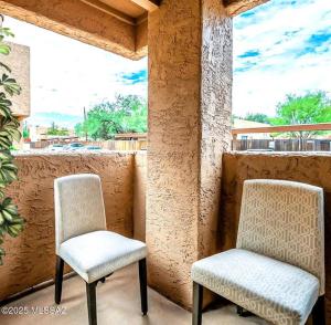 zwei Stühle auf einer Veranda neben einem Fenster in der Unterkunft Copper Star Condominiums in Tucson