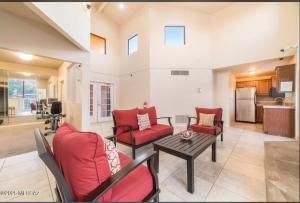 ein Wohnzimmer mit roten Stühlen und einem Tisch in der Unterkunft Copper Star Condominiums in Tucson