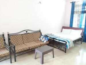 a living room with a couch and a bed at Richnest Apartment and villas Colva in Colva