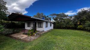 a small white house with a grass yard at Casa Vegas Panoramic Views near Monteverde in Turín
