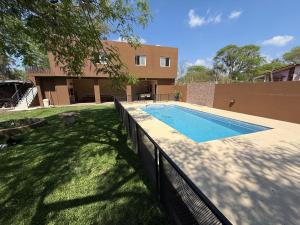 a swimming pool in a yard next to a house at La catalina in San Antonio